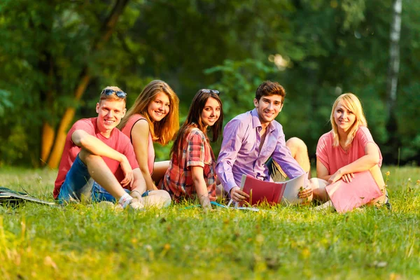 Група щасливих студентів з книгами в парку — стокове фото