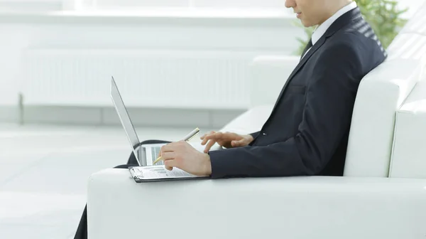 Uomo d'affari fiducioso che lavora sul computer portatile seduto nello spazioso — Foto Stock