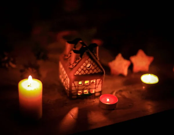 Gingerbread house candle on blurred background of the table. — Stock Photo, Image