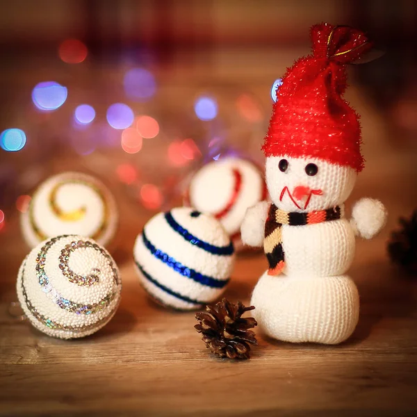 Kerstballen en een speelgoed sneeuwpop op kersttafel — Stockfoto