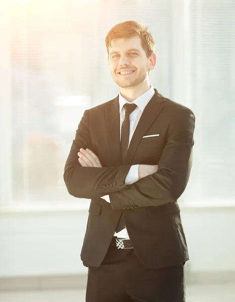 Jeune homme d'affaires souriant sur fond flou bureau — Photo