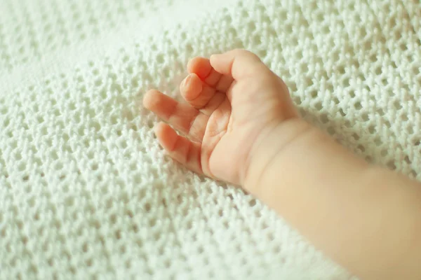 Main d'un nouveau-né sur une couverture blanche — Photo