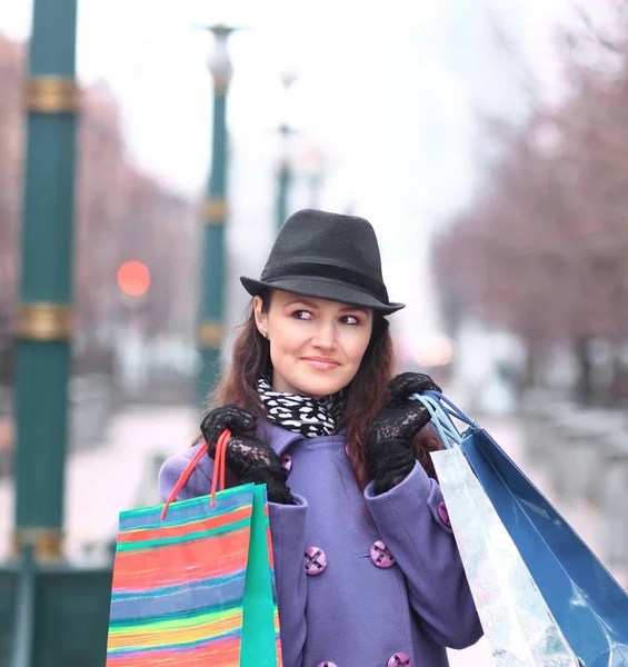 Close up.young mujer con bolsas de compras en el fondo de la ciudad —  Fotos de Stock