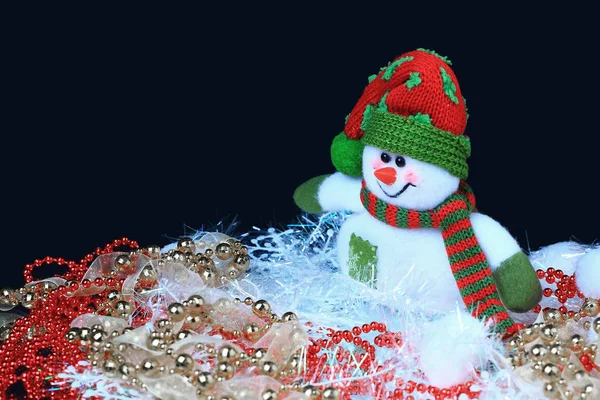 Snögubbe med julpynt på svart bakgrund — Stockfoto