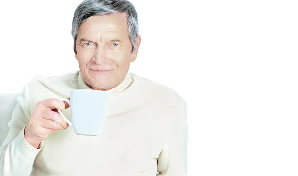 Portrait of senior man holding coffee mug, smiling at camera — Stock Photo, Image