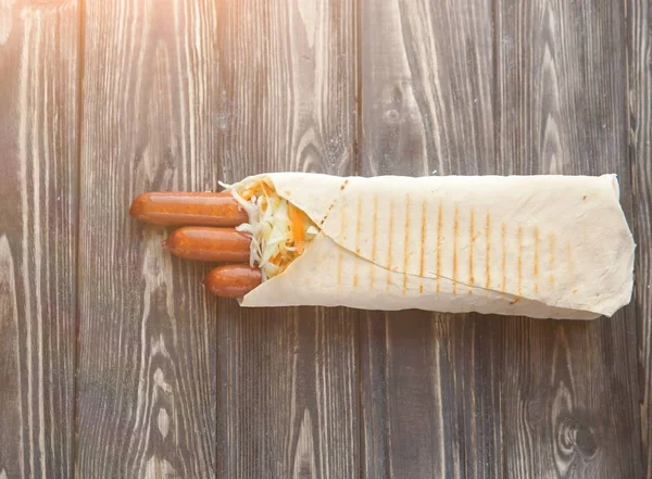 Gerookte worst in pita brood op een donkere houten background.photo met kopie ruimte — Stockfoto