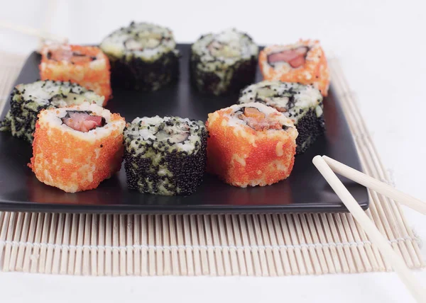 Sushi Set - different types of Maki sushi and chopsticks on a b — Stock Photo, Image