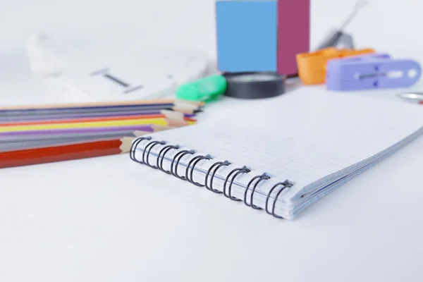 Notepad and blurred image of office supplies on white background — Stock Photo, Image