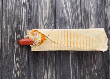 Pide üzerinde kopya alanı ile ahşap background.photo sosis ve marul sarılı