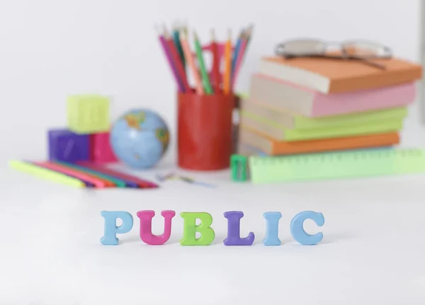 Word public on blurred background of school supplies .photo with copy space — Stock Photo, Image