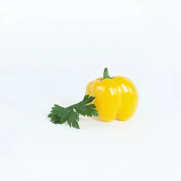 Poivron jaune, et un brin de persil .isolé sur un blanc — Photo