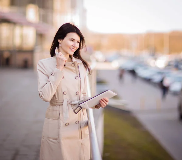 Modern business woman working on a digital tablet, standing next to an office building — Stock Photo, Image