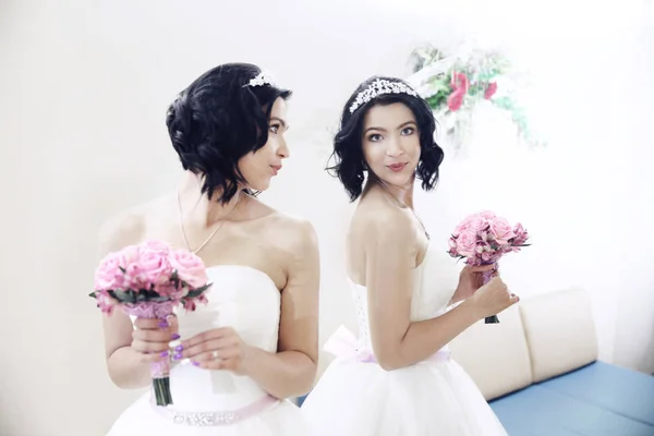 Närbild på en brud med bröllop bukett ser i spegeln — Stockfoto