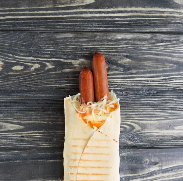 homemade sausages in pita bread on wooden background.photo with copy space