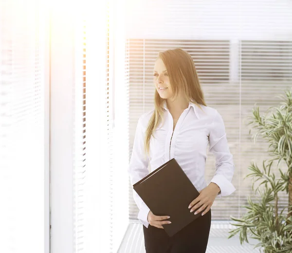 Exitosa mujer de negocios con clipbord de pie en una oficina moderna — Foto de Stock