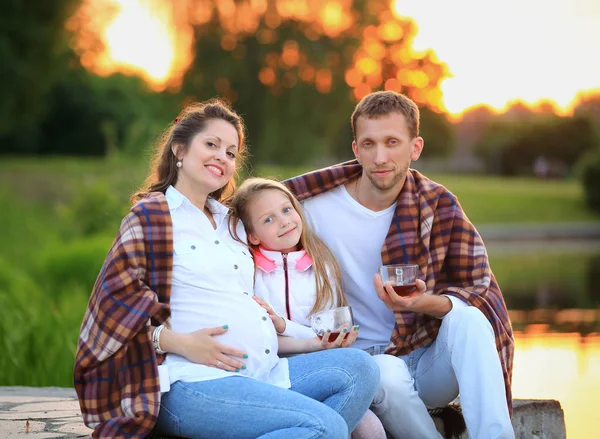 Koncept výchovy dětí - šťastná rodina zabalená v blanku — Stock fotografie