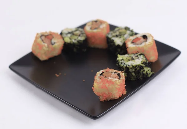 Набор суши-роллов на черной тарелке — стоковое фото