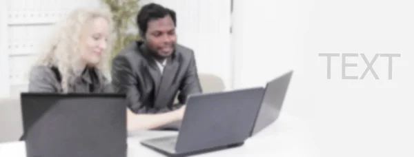 Younger employees discussing business issues in office in a blur — Stock Photo, Image