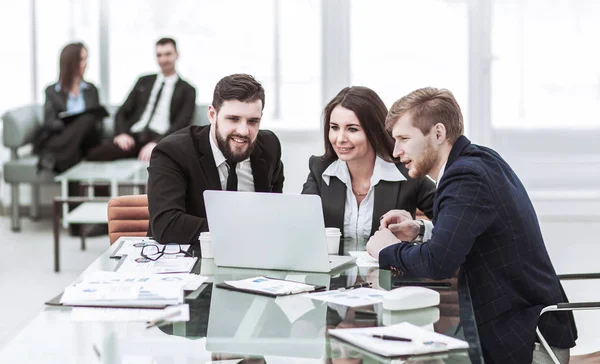 Exitoso equipo de negocios trabajando en el ordenador portátil y haciendo el informe financiero actual — Foto de Stock