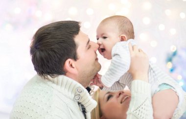 sevgi dolu anne Noel ağacın önünde duran çocuk oynamak.