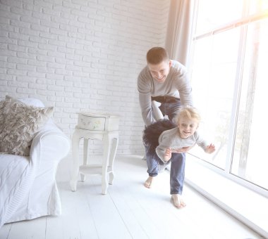 Baba küçük kızı ferah bir oturma odası ile oynarken