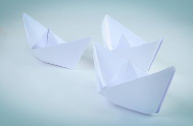 origami tekniğinde yapılmış üç kağıt tekne.