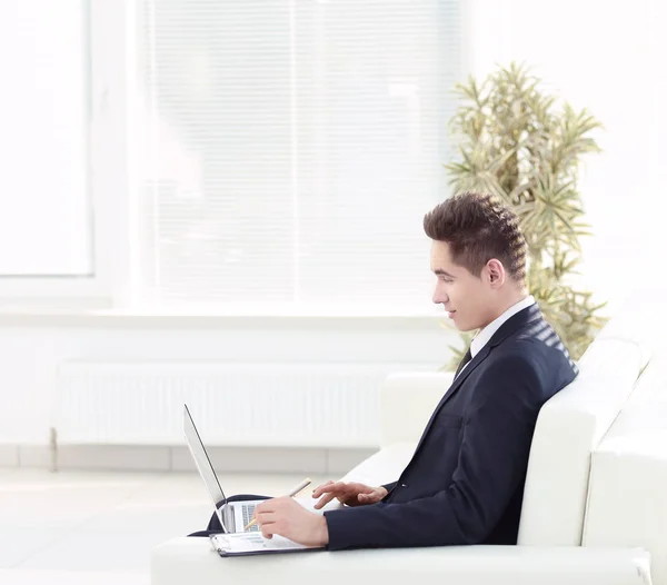 Homme d'affaires confiant travaillant sur ordinateur portable assis dans le spacieux — Photo