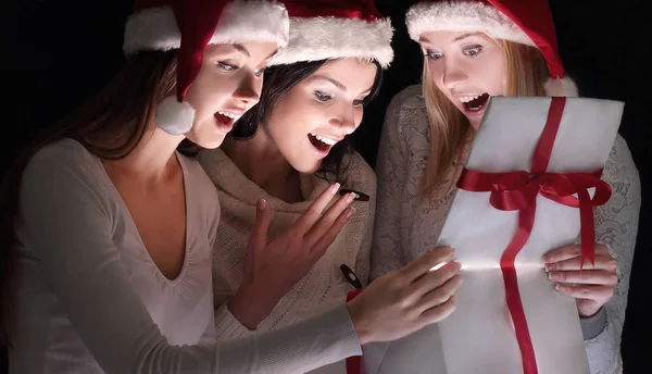 Grupo de estudantes do sexo feminino em trajes de Papai Noel abrindo um b — Fotografia de Stock