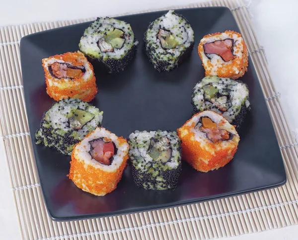 Conjunto de sushi - diferentes tipos de sushi Maki e pauzinhos em um b — Fotografia de Stock