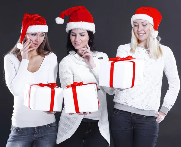 Três jovens mulheres em traje de Papai Noel com loja de Natal — Fotografia de Stock