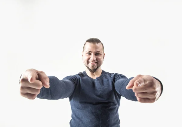 Sonriente atlético chico culturista en jeans y una camiseta señalando — Foto de Stock