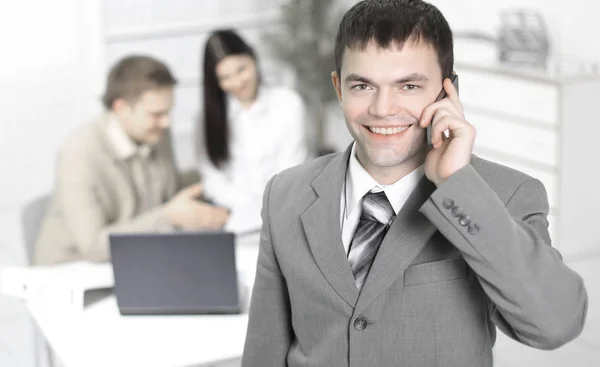 Employee talking on cell phone on office background — Stock Photo, Image