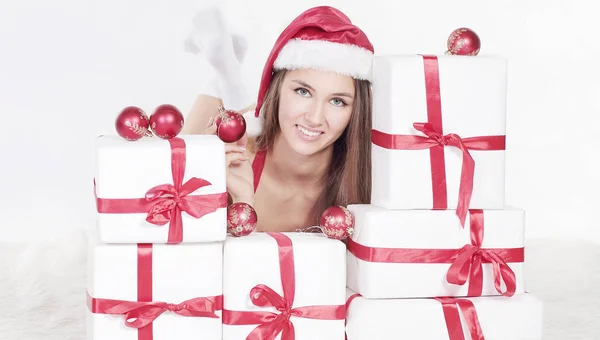 Beautiful young woman in Christmas suit with a stack of Christm Royalty Free Stock Photos