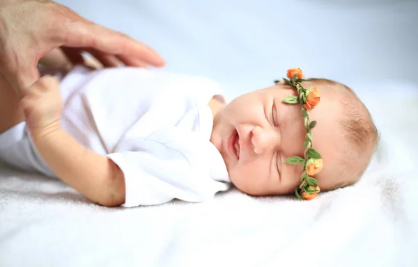 Serene pasgeboren baby in de krans liggend op het witte doek — Stockfoto