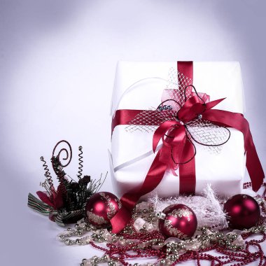 Beyaz hediye kutusu ve beyaz bir arka plan üzerinde Noel süsleri