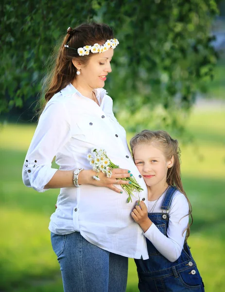 Concetto di educazione - una madre incinta e la sua piccola figlia — Foto Stock