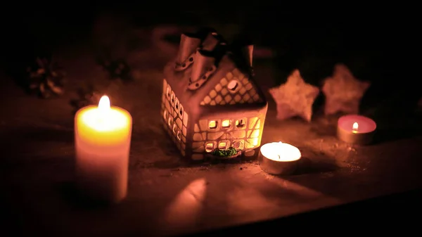 Gingerbread house candle on blurred background of the table. — Stock Photo, Image