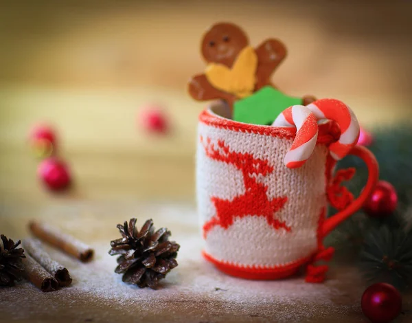 Christmas Cup ornament and a fun gingerbread on a wooden table — Stock Photo, Image