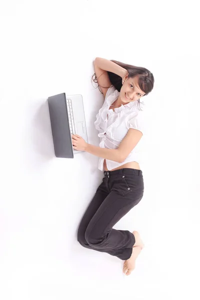 Mujer joven con el ordenador portátil que miente en el suelo .isolated en blanco —  Fotos de Stock