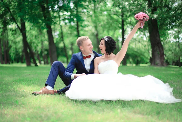 Счастливый жених и невеста, сидящие в лавке — стоковое фото