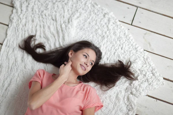 Close up.thoughtful mujer joven acostada en la alfombra blanca en la sala de estar — Foto de Stock