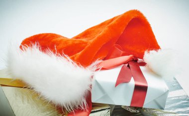 Yakın plan. İçinde hediyeler ve Noel Baba şapkası olan kutular..