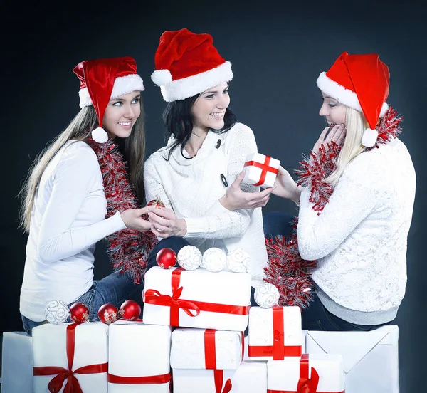 Três meninas felizes vestidas como Papai Noel sentado com um bu — Fotografia de Stock