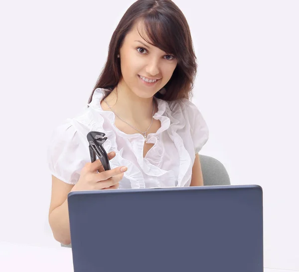 Νεαρή γυναίκα με ένα ζευγάρι των πενσών κάθεται μπροστά από ένα ανοιχτό laptop — Φωτογραφία Αρχείου