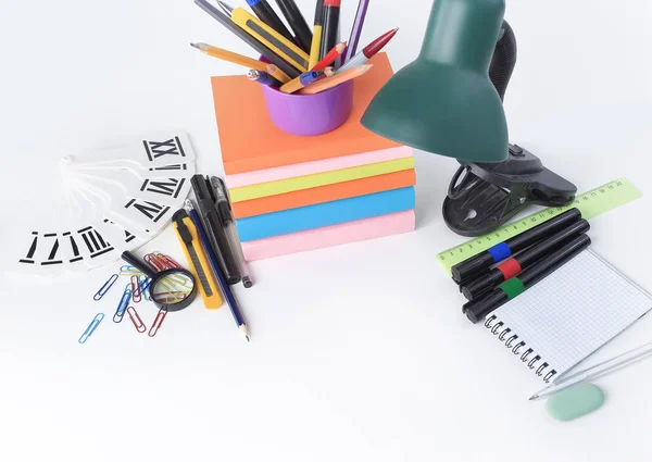 Lámpara de mesa y coloridos útiles escolares sobre fondo blanco .photo con espacio de copia — Foto de Stock