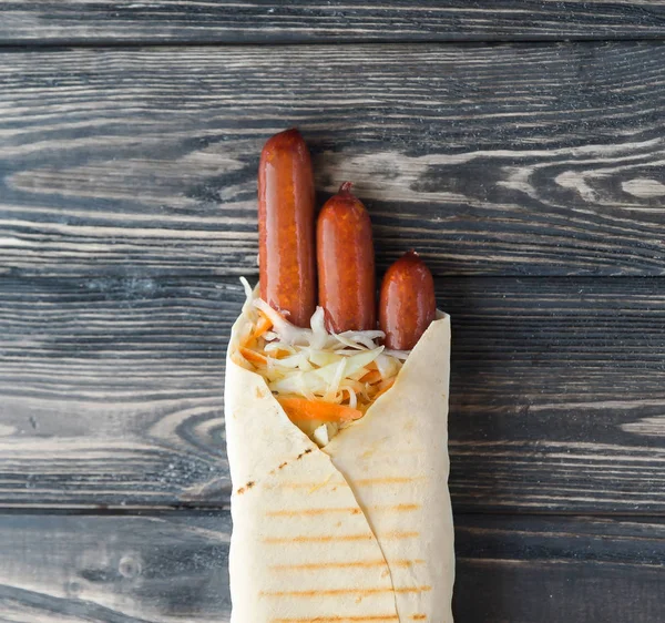 Schweinswürste in Fladenbrot auf hölzernem Hintergrund. Foto mit Kopierfläche — Stockfoto