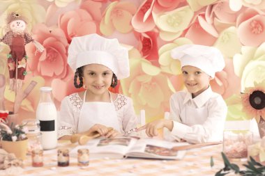 lezzetli yemek pişirmek için bir şef şeklinde mutlu küçük çocuklar