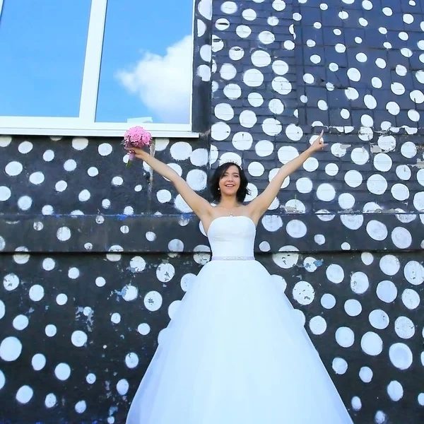 Novia con ramo en el fondo de los edificios de la ciudad —  Fotos de Stock