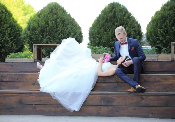 Молода пара відпочиває в парку після весілля — стокове фото