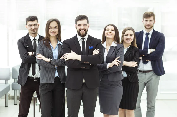 Porträtt av en sammansvetsad business team står bredvid varandra i lobbyn på kontoret — Stockfoto